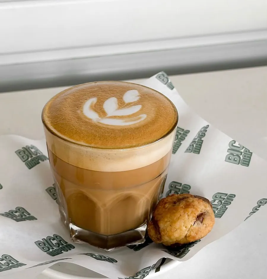 Cortado num copo de vidro com um cookie