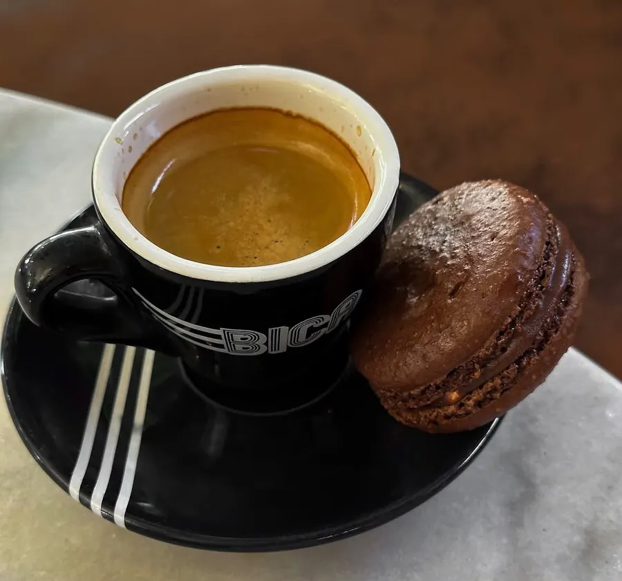 Espresso numa chávena preta com um macaron